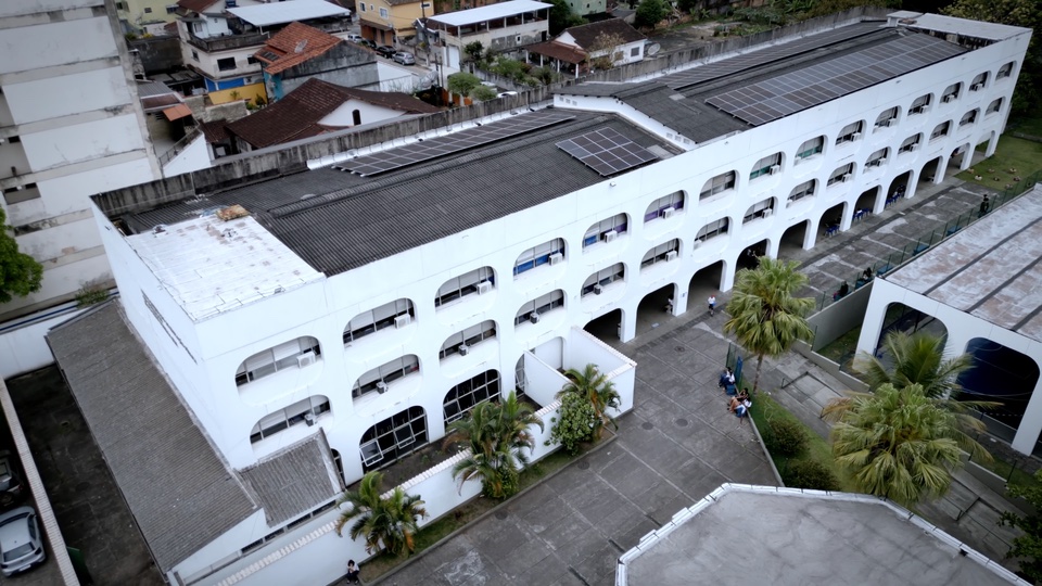 Vista aérea de um edifício escolar branco cercado pela cidade