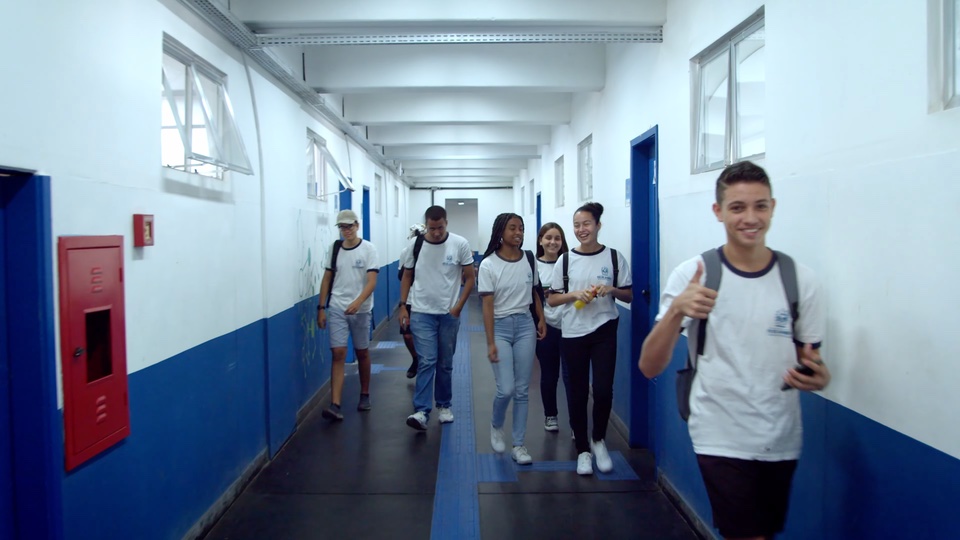 Jovem fala no pátio de uma escola em um dia chuvoso