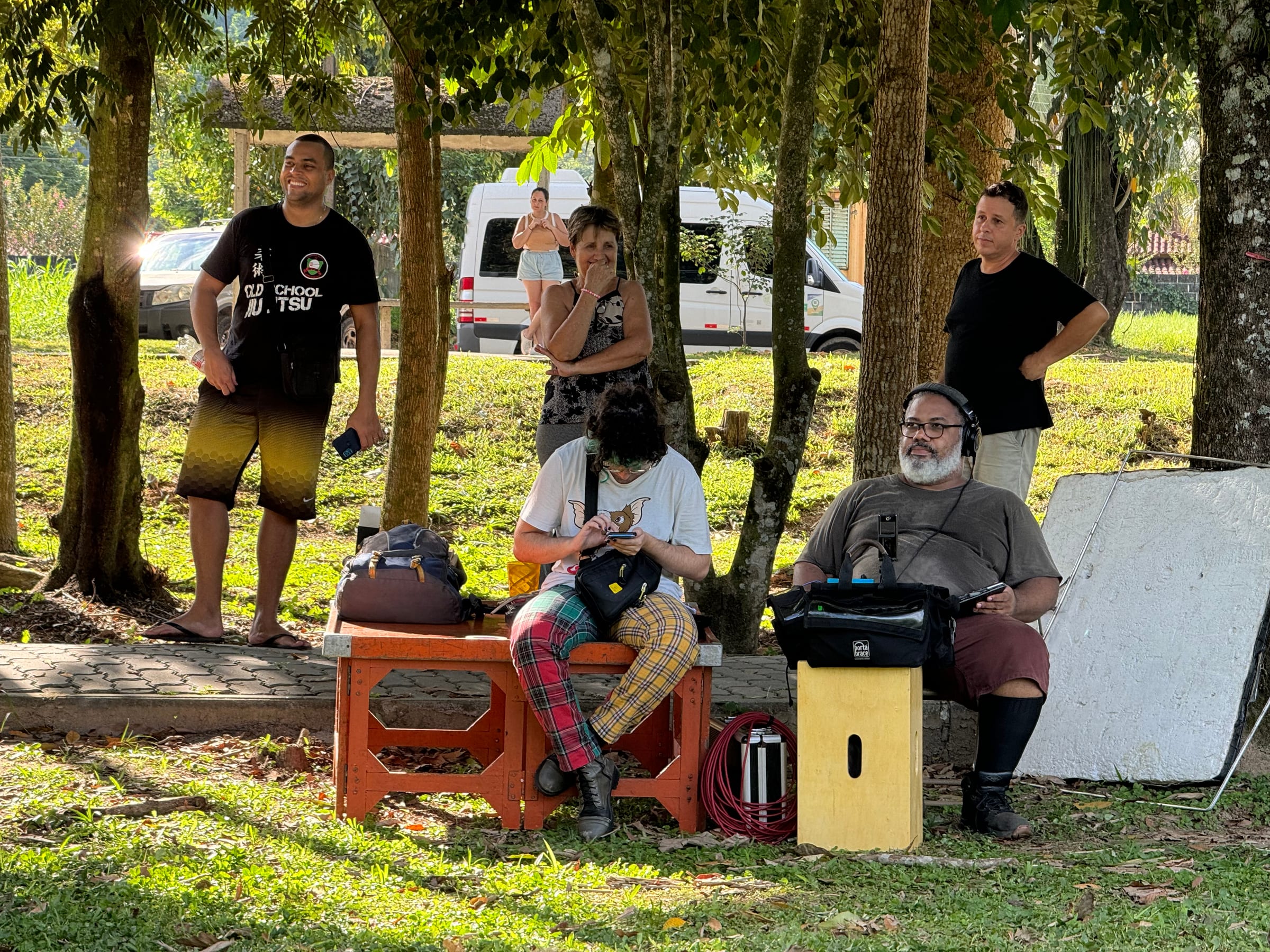 Equipe reunida em torno da preparação de uma cena ao ar livre